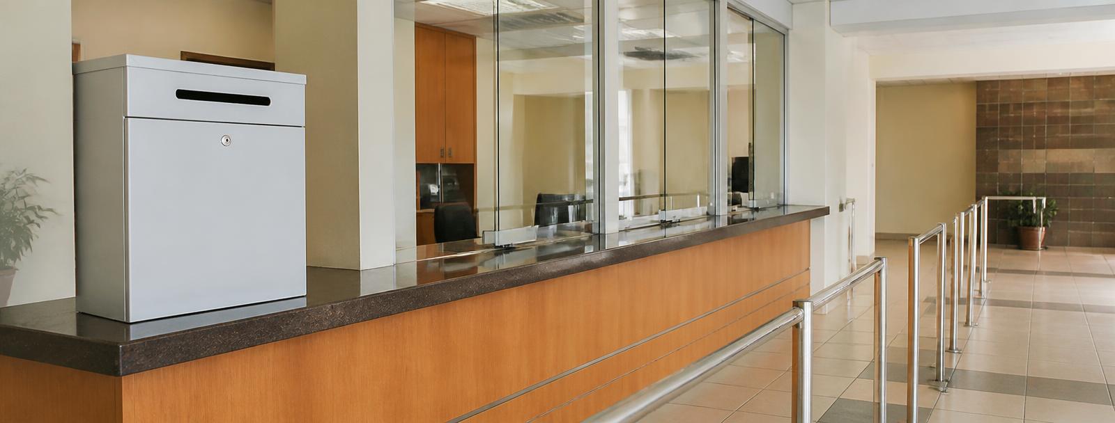 A tender submission counter in a South African municipal building, with a sealed-bid drop box on the counter